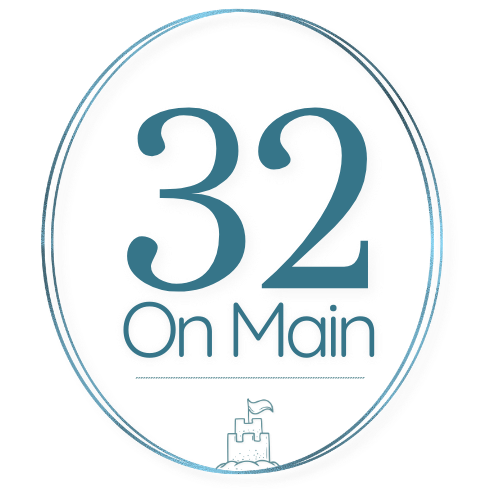 Circular 32 on Main logo with large “32” above the words “on Main,” in teal and grey tones, with a small castle icon at the bottom.